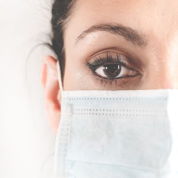 Half-faced portrait of a female doctor in the protective mask. Doctor in a medical mask. Patient, nurse. Protection against coronovirus COVID-19. Coronavirus outbreak.