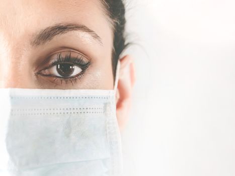 Half-faced portrait of a female doctor in the protective mask. Doctor in a medical mask. Patient, nurse. Protection against coronovirus COVID-19. Copy space.