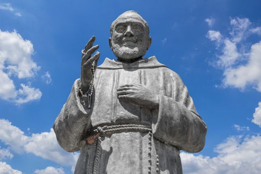 Statue of Saint Father Pio on sky background. Ideal for concepts or events.