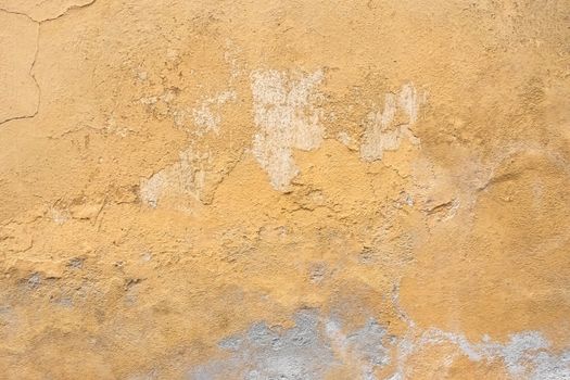 Grunge plaster wall with yellow scratched background. Old wall with peel swamp color stucco texture. Vintage wallpaper. Decay and cracks. Rough abstract surface.
