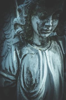Antique stone statue of sad angel. Retro stylized. Religion, faith, death, resurrection, eternity concept.
