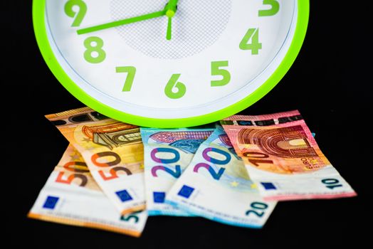 euro banknotes under a clock indicates time and money