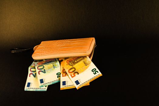 women's wallet on top of banknotes of different currency