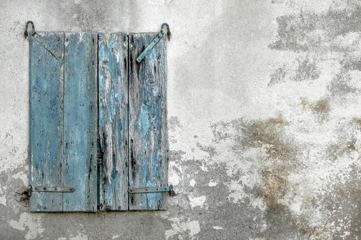 Old shabby stone wall with grungy wooden window. Space for text.