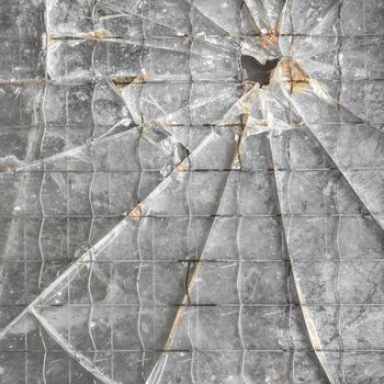Shattered reinforced glass background. Closeup of broken glass texture.