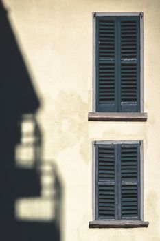 Two closed windows and the shadow of the building opposite