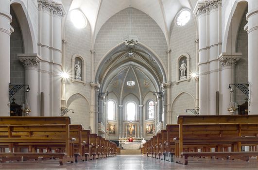 Interior view of a church. Beautiful view on nave from altar inside cathedral church. Interior of catholic basilica with sun rays from windows.