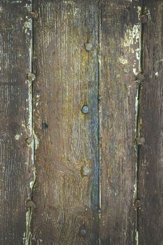 Intage image of a wooden dark background with old rusty nails. Rough and faded tones.