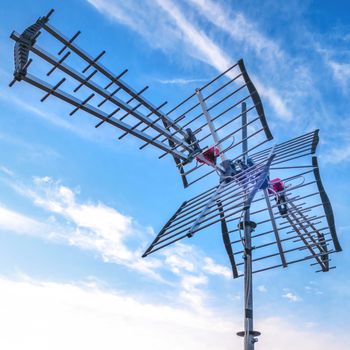 Television antenna with blue sky background. Directional antenna for reception of digital television broadcasting DVB-T and DVB-T2 against a blue sky.