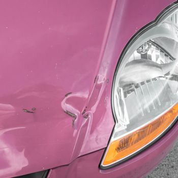 Damaged bodywork. Dents and scratch marks on a car's hood. Close-up.