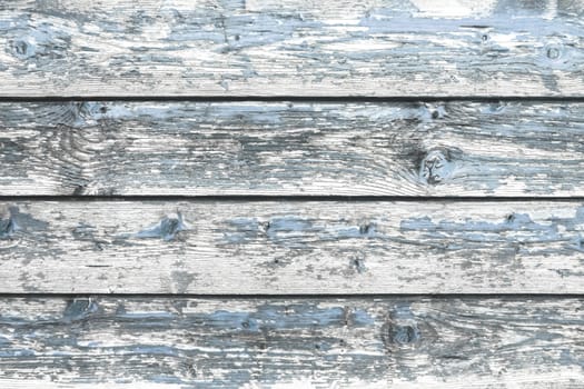 Color-Peel wood texture. Battered faded old light blue painted wooden boards with peeling. Wooden abstract background, texture.