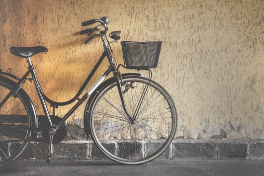 Vintage bicycle leaning against a wall. Retro style photo.