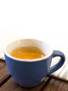 Cup of coffee on wooden table and white background for copy space.