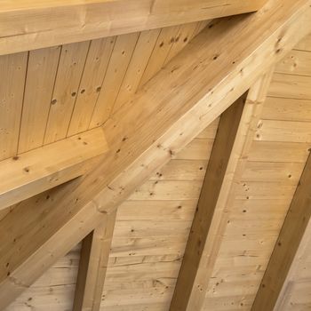 Wooden ceiling with exposed beams. Interior wooden roof with exposed beams.