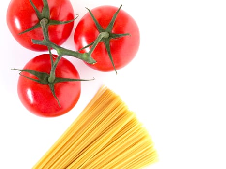 Setting pasta with raw spaghetti and tomatoes isolated on white background. Top view. Copy space.
