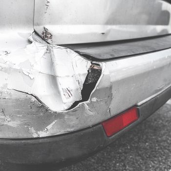 Dented car. Vehicle bumper dent broken by car crash. Road accidents.