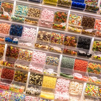 Candy display on a market. Numerous colorful candies in different sections on display.