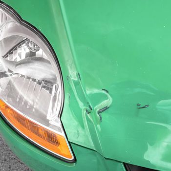 Damaged bodywork. Dents and scratch marks on a car's hood. Close-up.