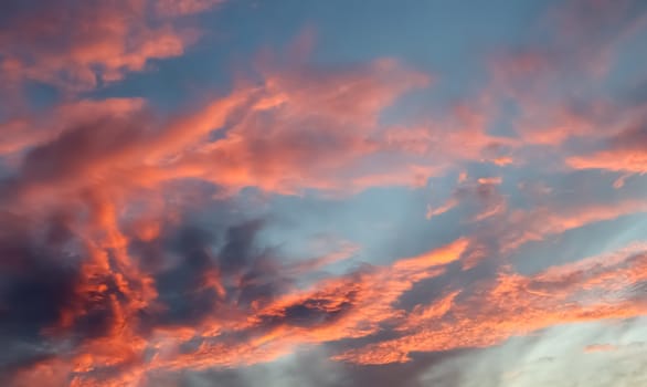 Beautiful panorama of orange and yellow clouds at sunrise and sunset in a blue sky