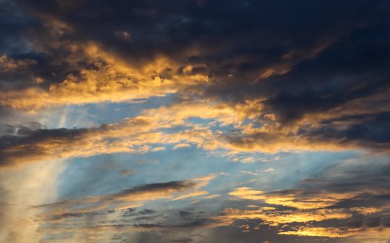 Beautiful panorama of orange and yellow clouds at sunrise and sunset in a blue sky