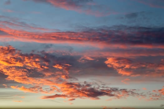 Beautiful panorama of orange and yellow clouds at sunrise and sunset in a blue sky