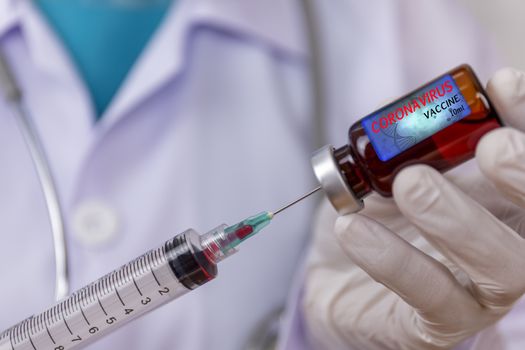 Covid-19, Coronavirus vaccine concept. Doctor, nurse, scientist, researcher hand in latex gloves holding vaccine in glass vial, Hands of doctor holding syringe and take vaccine from glass vial.
