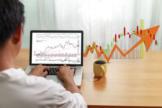 Business and financial concept Bbusinessman use laptop computer trade stock market with candlestick chart background. Businessman use computer network control trade buy and sell stock market