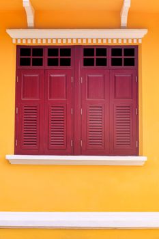 Old twin wood windows with yellow wall background. Old style double wood windows.
