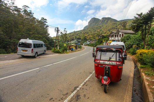 Kandy, Sri Lanka - April 13, 2017: Tuk tuk parked next to road in Sri lankan highlands.