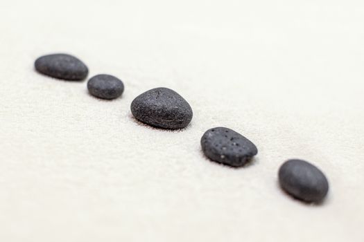 Five volcanic lava stones on white cotton towel.