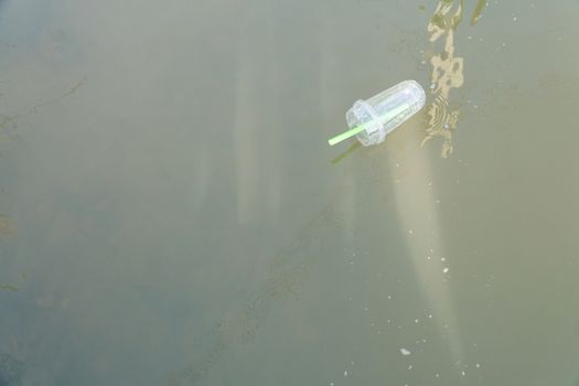 Plastic glass of bubble milk tea was left floating in the river