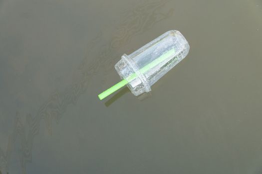 Plastic glass of bubble milk tea was left floating in the river