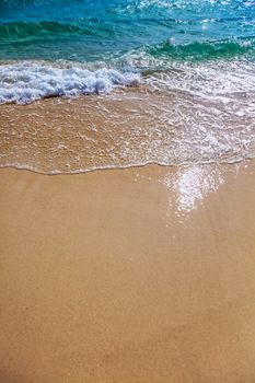 Sand beach and blue sea surf waves close up