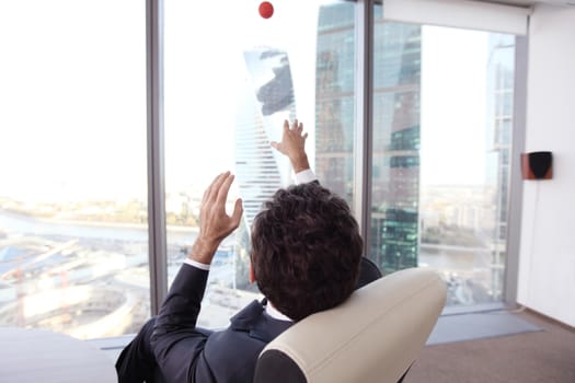 Business man playing with a basketball at the office