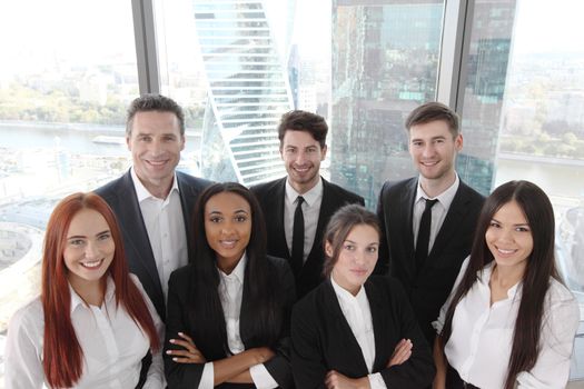 Portrait of business team of men and women in office with view on skyscrapers