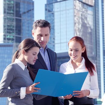 Portrait of business team outside office on skyscrapers background