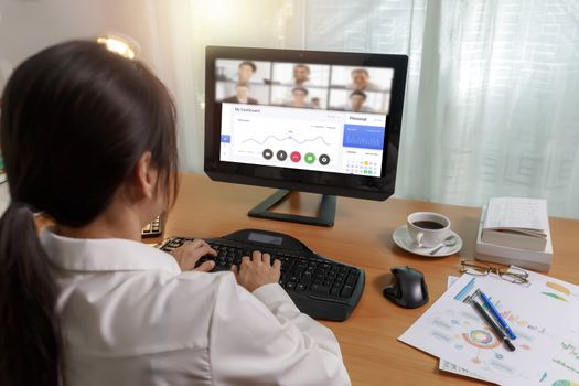 Asian business women working at home online meeting with video conference on computer. Business people using computer online meeting and speaking with team group.