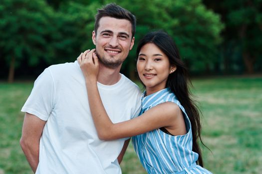 young couple outdoors in the park hugs dating vacation