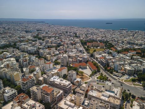 Day top panorama of European city with residential blocks of flats before a calm seafront on a sunny day.