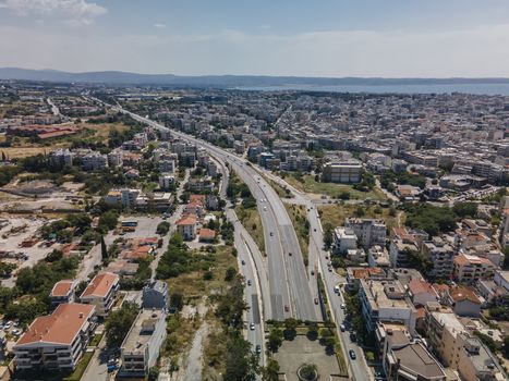Day top panorama of European city with main highway & passing cars through residential blocks of flats.
