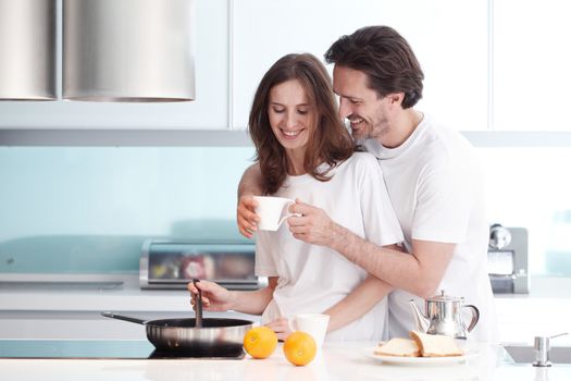 Happy couple cooking breakfast together in the kitchen