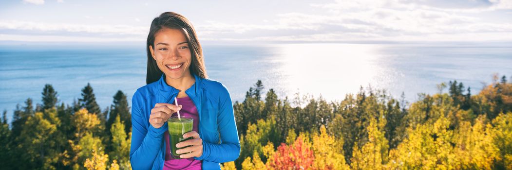 Outdoor fall nature Asian woman drinking fresh green vegetable smoothie as a healthy breakfast or lunch detox on home terrace in beautiful morning nature outdoors. Happy smiling fitness girl.