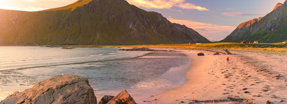 Landscape at sunset with beach and mountains. Purple sky in background. Travel in Norway, Scandinavia, Europe.