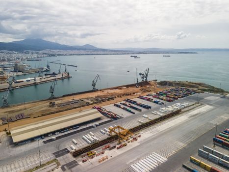 Day top panorama of large motorized cranes on sea port, with cargo containers on commercial berthing dock pier.