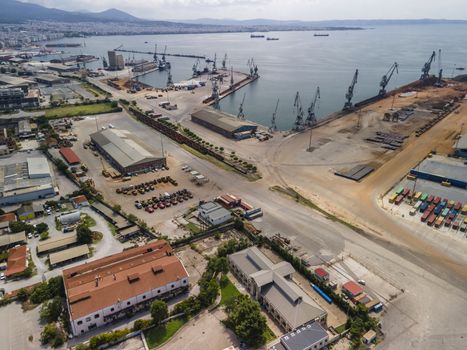 Day top panorama of large motorized cranes on sea port, with cargo containers on commercial berthing dock pier.