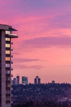 Sunset view from high-rise building on crimson sky background.