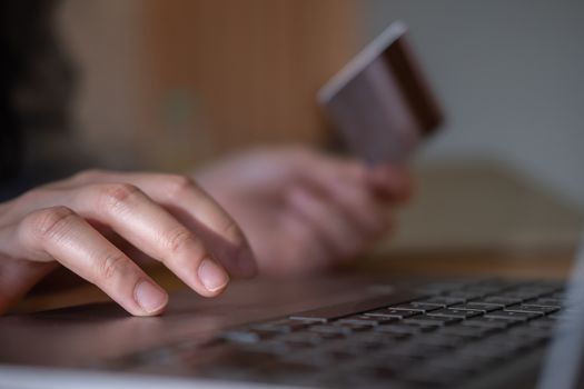 Close up hands holding credit card and using laptop. Online shopping.