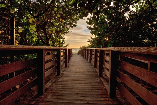 Boardwalk leading toward Delnor Wiggins State Park at sunset in Naples, Florida.