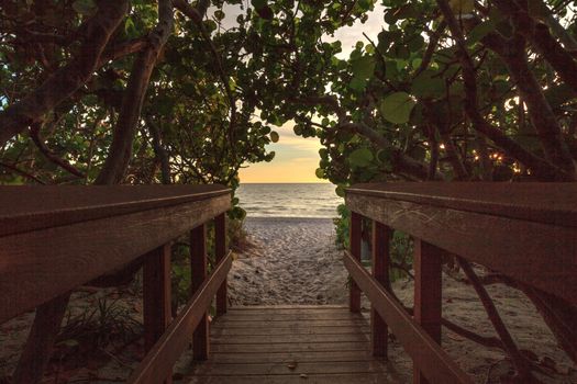 Boardwalk leading toward Delnor Wiggins State Park at sunset in Naples, Florida.