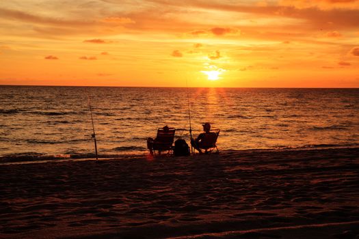 Naples, Florida, USA – August 16, 2020: Two people fishing at Sunset at Delnor Wiggins State Park in Naples, Florida.